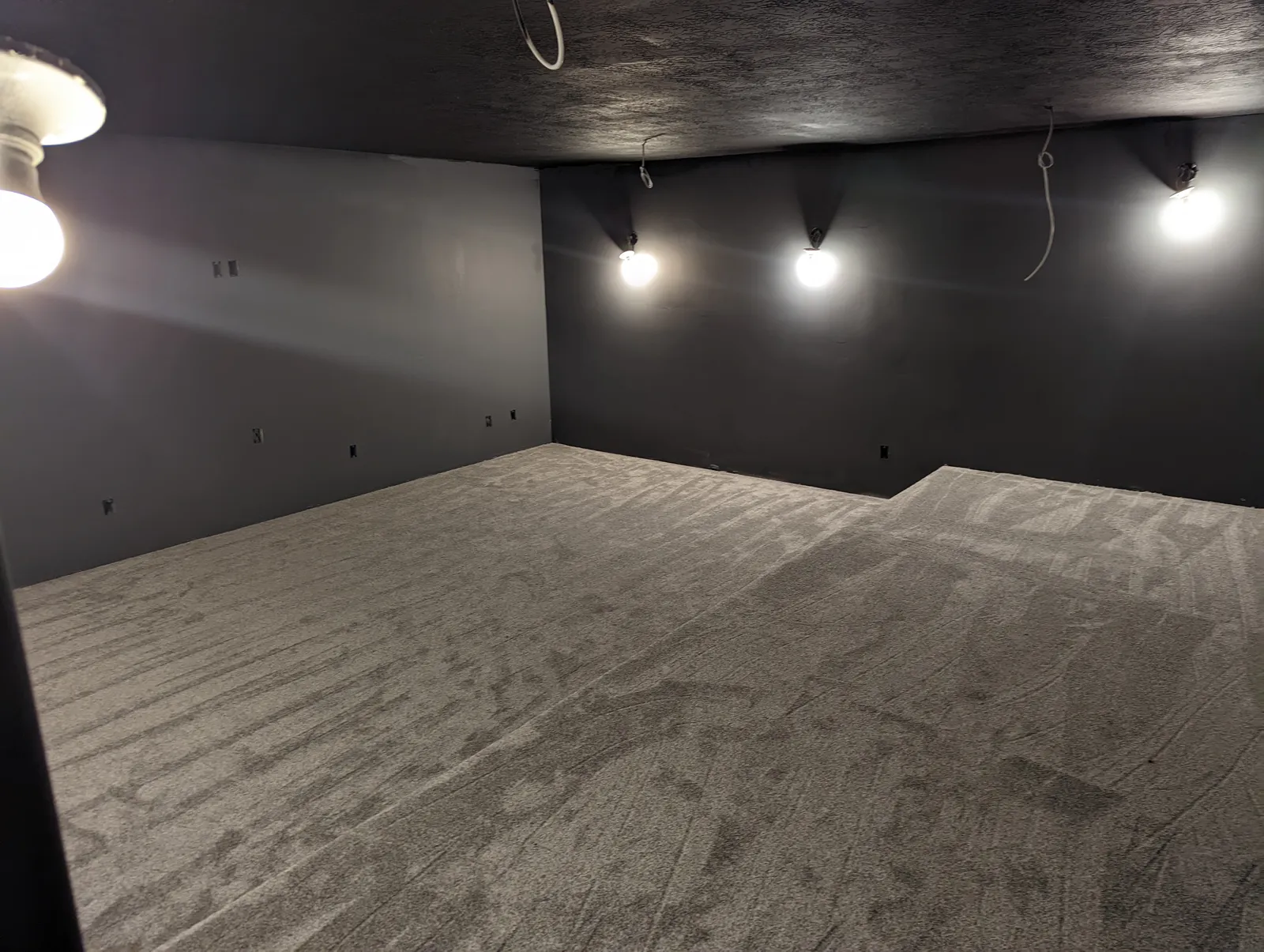Theater room with carpeted tiered seating risers ready for equipment
