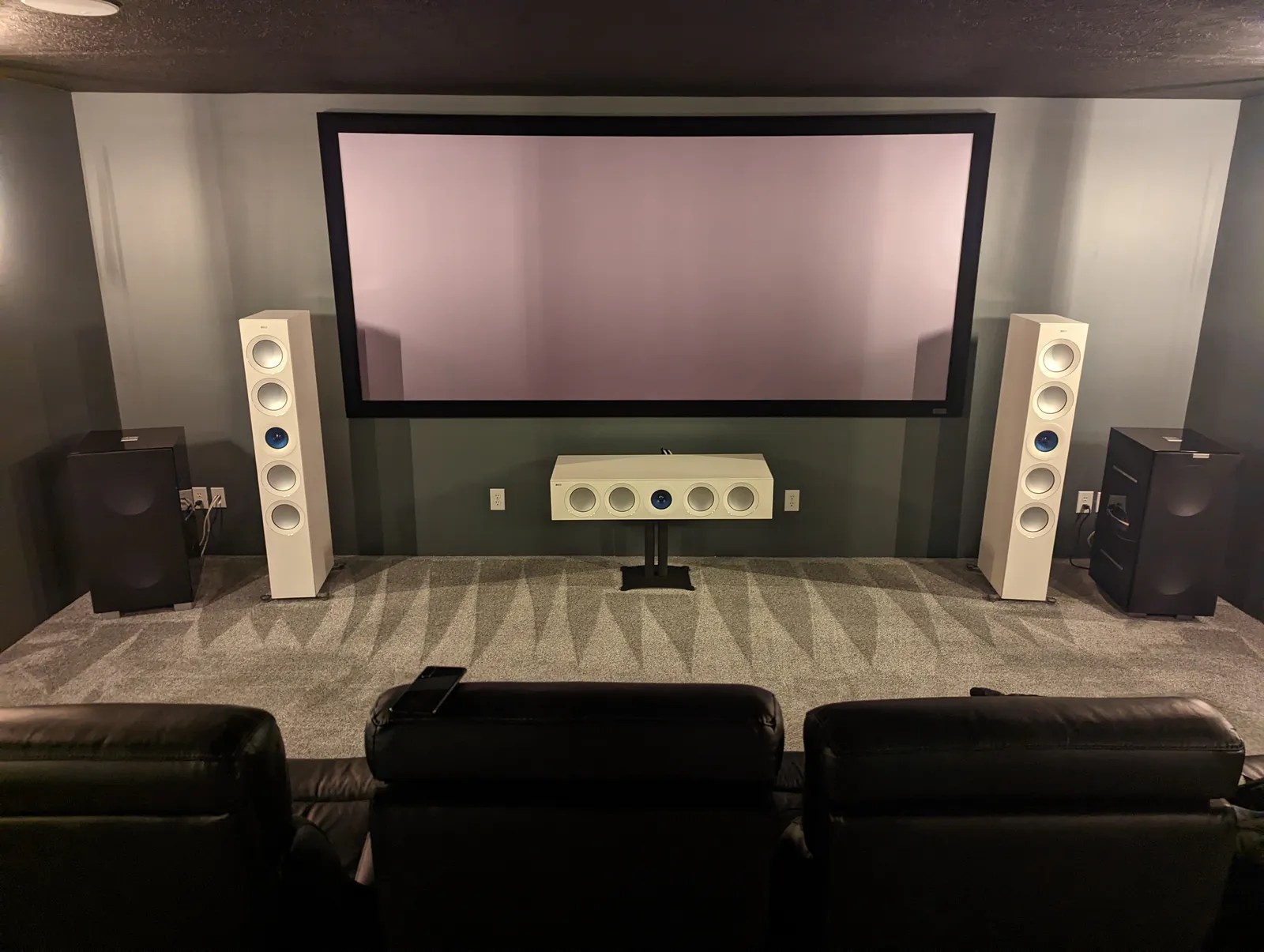 Projection screen with reference tower and center speakers and dual subwoofers installed